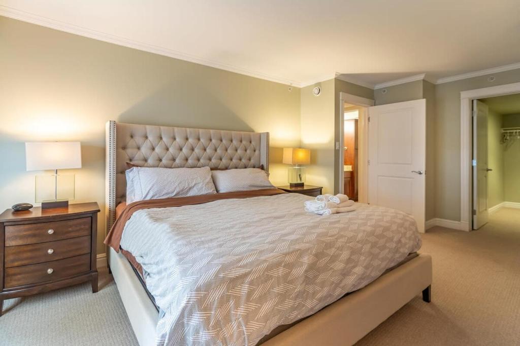 ein großes Schlafzimmer mit einem großen Bett und einem Nachttisch in der Unterkunft Lovely Waterfront Apt #807 with AC in Halifax