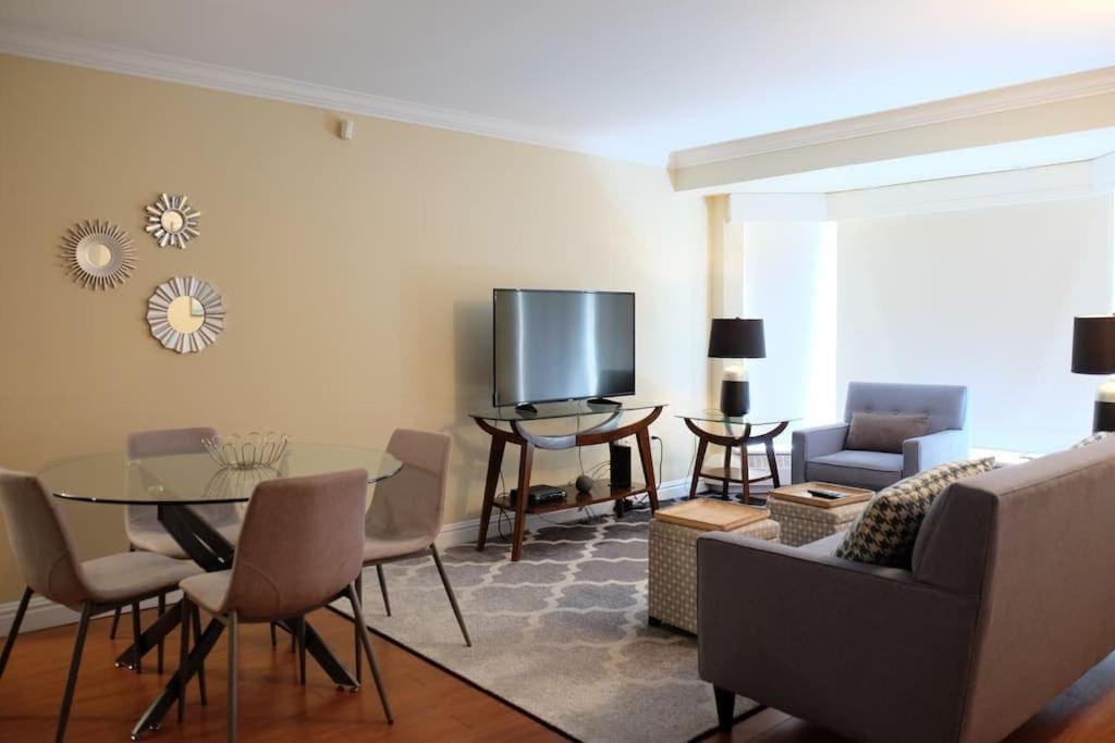 a living room with a table and a tv at Deluxe Downtown Apt #404 with AC in Halifax