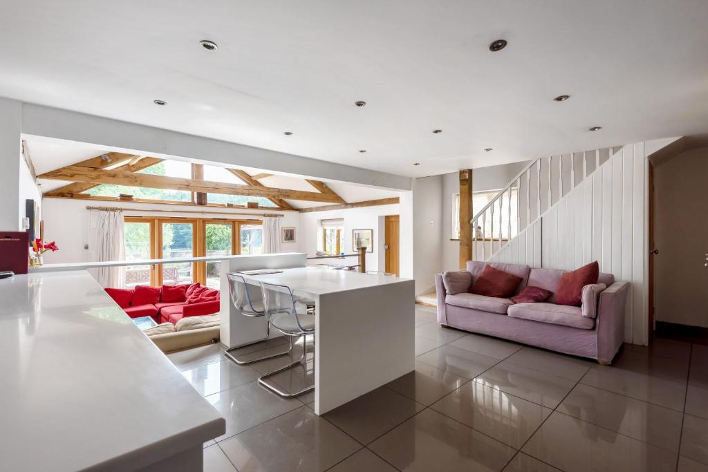 a kitchen and living room with a couch and a table at Prestwick Oak - 2 Kingsize Ensuite - Openplan Contemporary - Rural - Garden in Chiddingfold