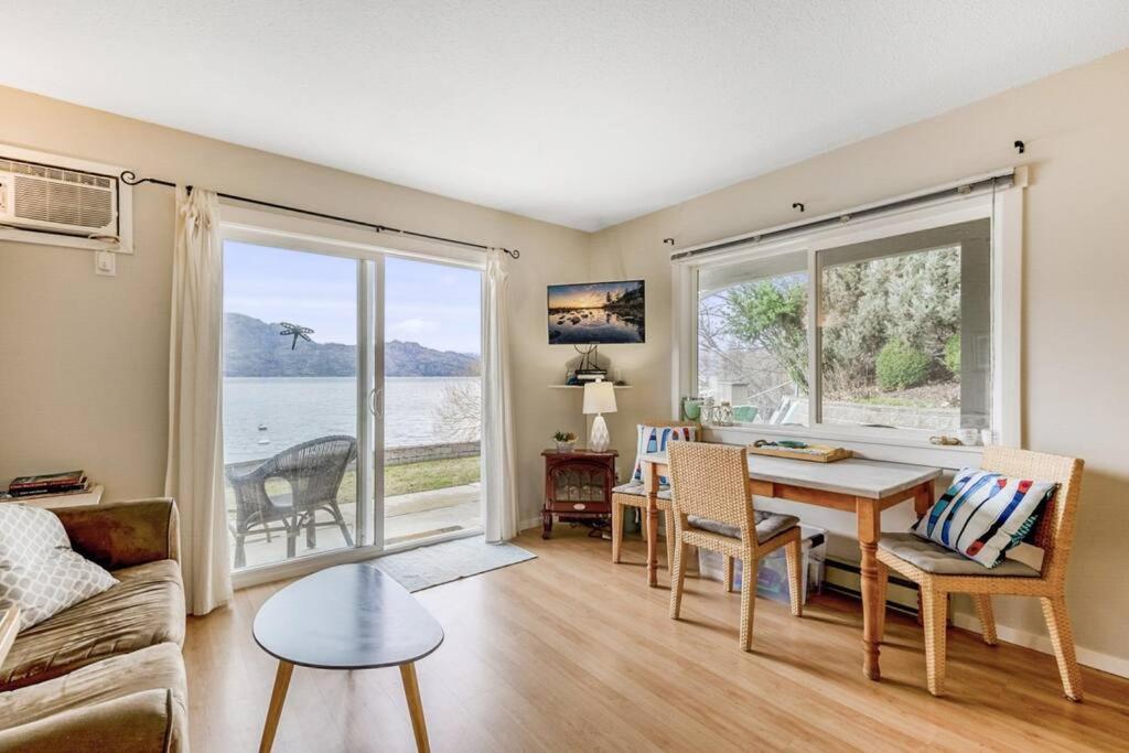a living room with a table and a large window at The Lakeside Cabin with wide outside space #105 in West Kelowna