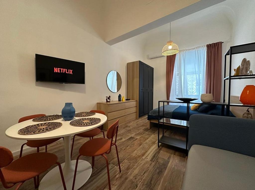 un soggiorno con letto, tavolo e sedie di Etna charme apartment a Catania
