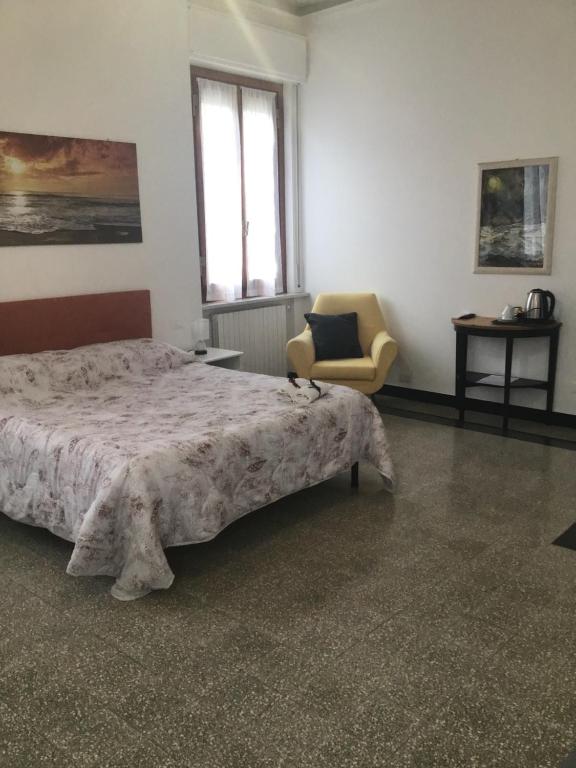 sypialnia z łóżkiem, krzesłem i oknem w obiekcie La Rosa Dei Venti w mieście Finale Ligure