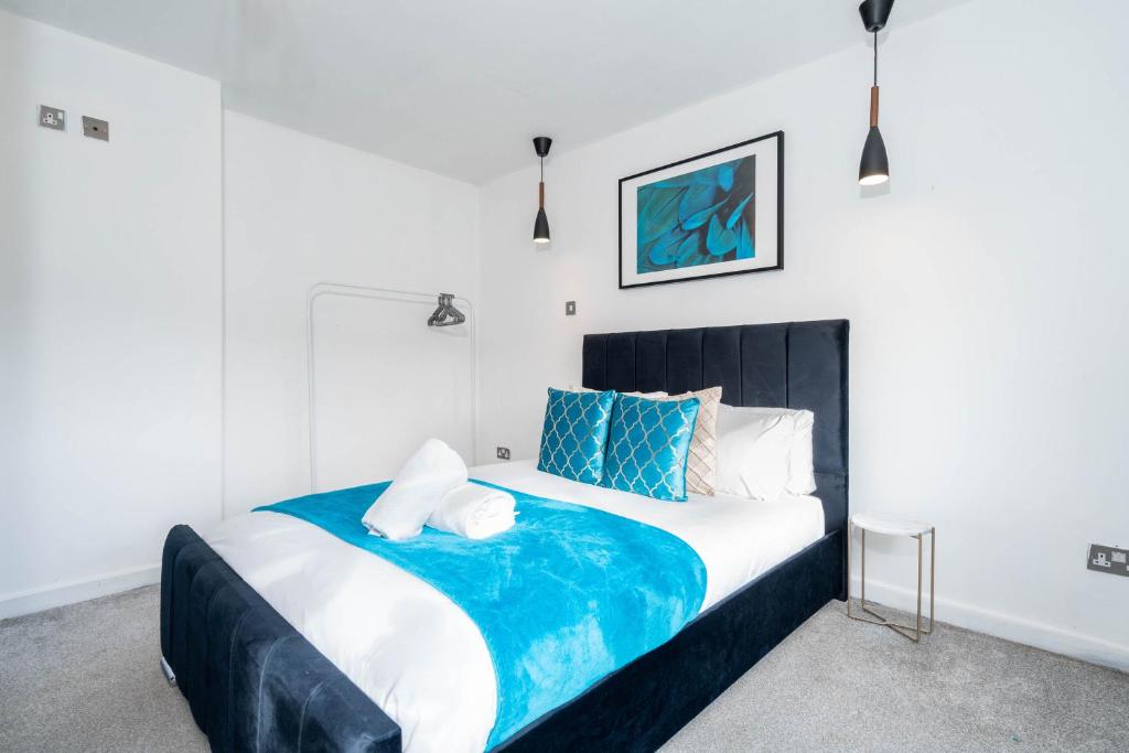 a bedroom with a large bed with blue and white pillows at Five Bedroom & Five Bathroom House - Netflix - WIFI - Garden - Off-Street - Parking 376M in Birmingham