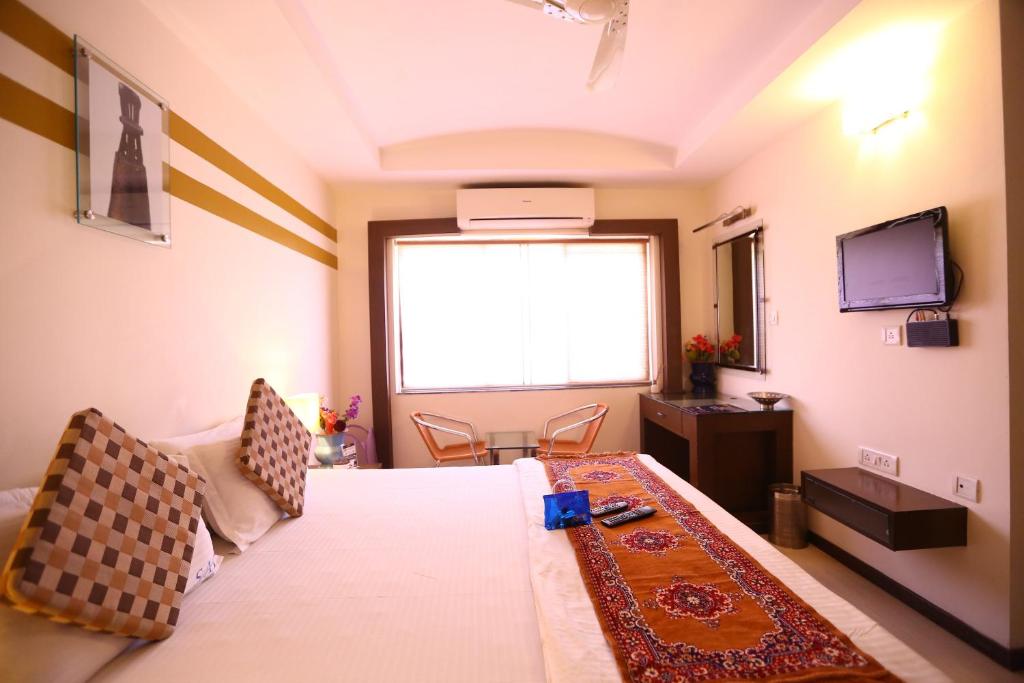Camera con letto, TV e finestra. di Capital O J2 Service Appartment a Chennai