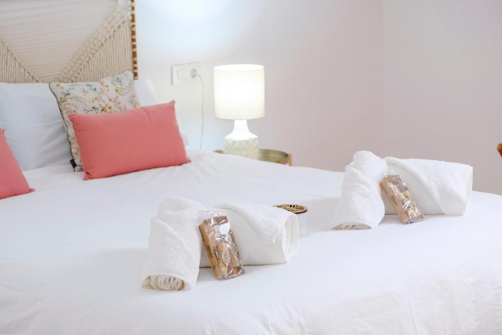- un lit blanc avec des serviettes et des oreillers dans l'établissement El Deseo del Carmen, à El Burgo de Osma