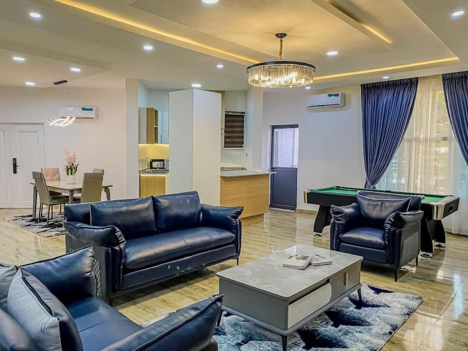 a living room with couches and a pool table at Emma's Court in Lagos