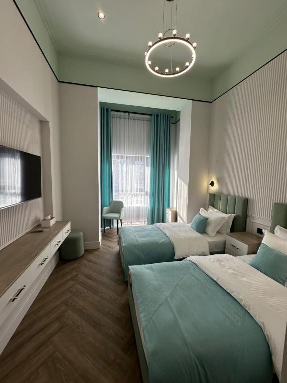 a hotel room with two beds and a television at Five Hotel in Prigorodnyy