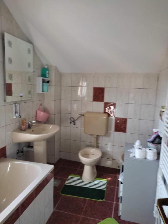 a bathroom with a toilet and a sink and a tub at Sobe Aida in Sarajevo