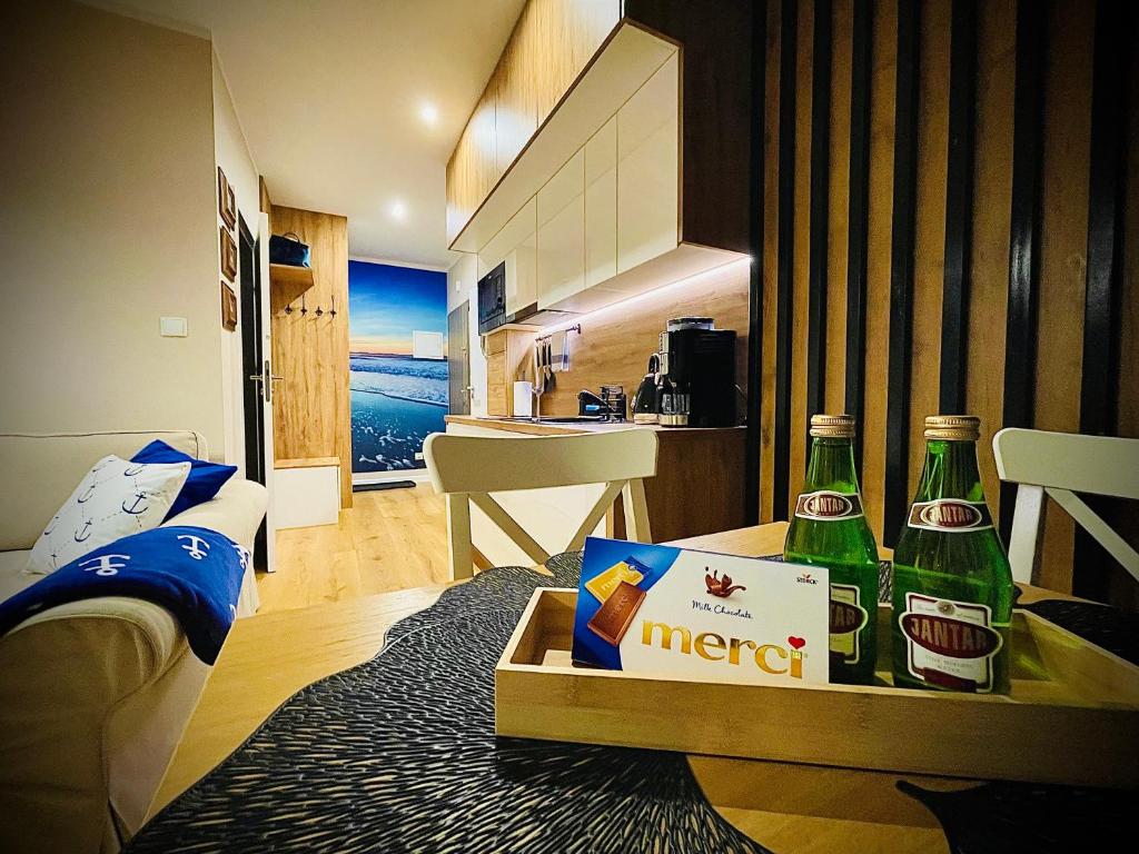 a room with two bottles of beer on a table at Sunset Resort Apartament Marco Marina in Grzybowo