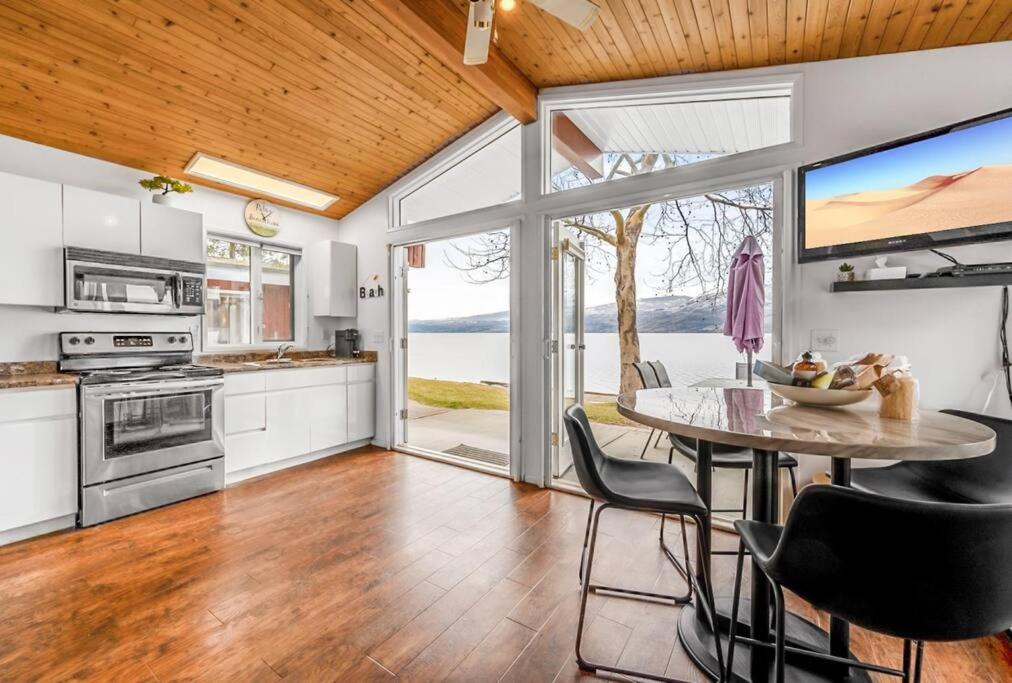 a kitchen with a table and chairs and a large window at Beautiful Cabin Right next to Lake Okanagan #5 in West Kelowna