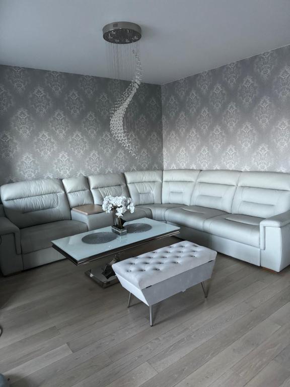 a living room with a couch and a table at AKOYA APARTMENTS Bianco in Koszalin