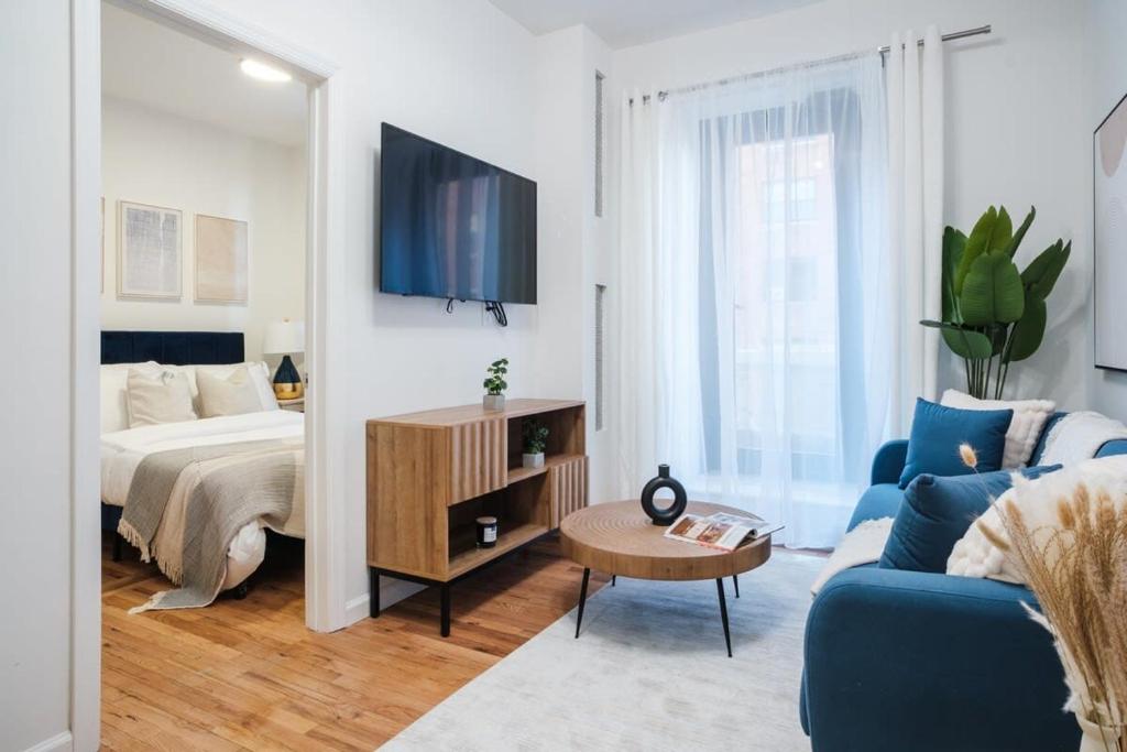 een woonkamer met een bed en een blauwe bank bij 74-4A 2BR 2baths in Prime Upper West Side w d GYM in New York