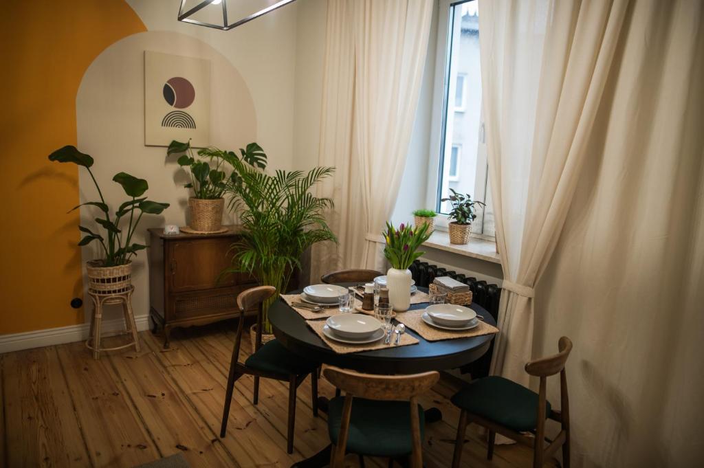 a dining room with a table and chairs and a window at Apartament Wspomnień in Zamość