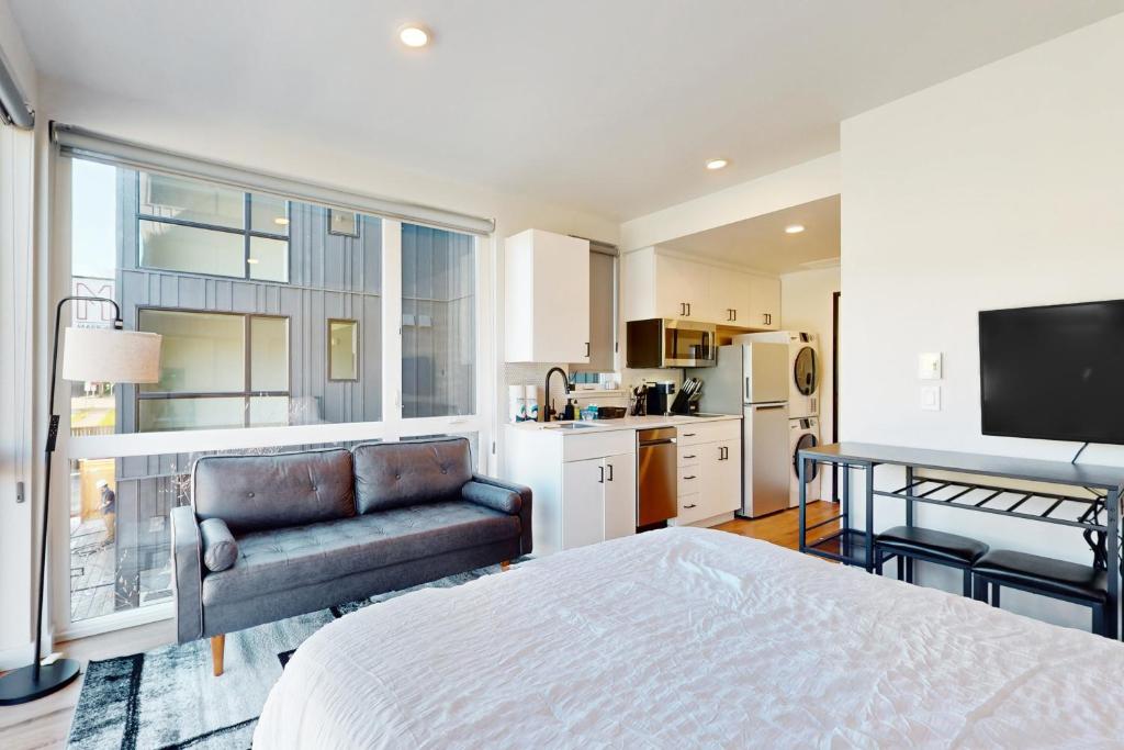 a bedroom with a bed and a couch and a kitchen at Marion Place in Seattle