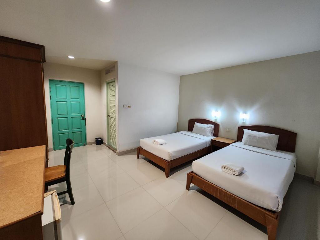 Ban Krabi Yai的住宿－Baanmai Residence，一间设有两张床和绿门的房间