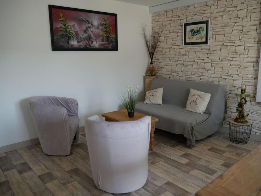 uma sala de estar com um sofá e duas cadeiras em Les Loges Farm em Le Breuil-sous-Argenton