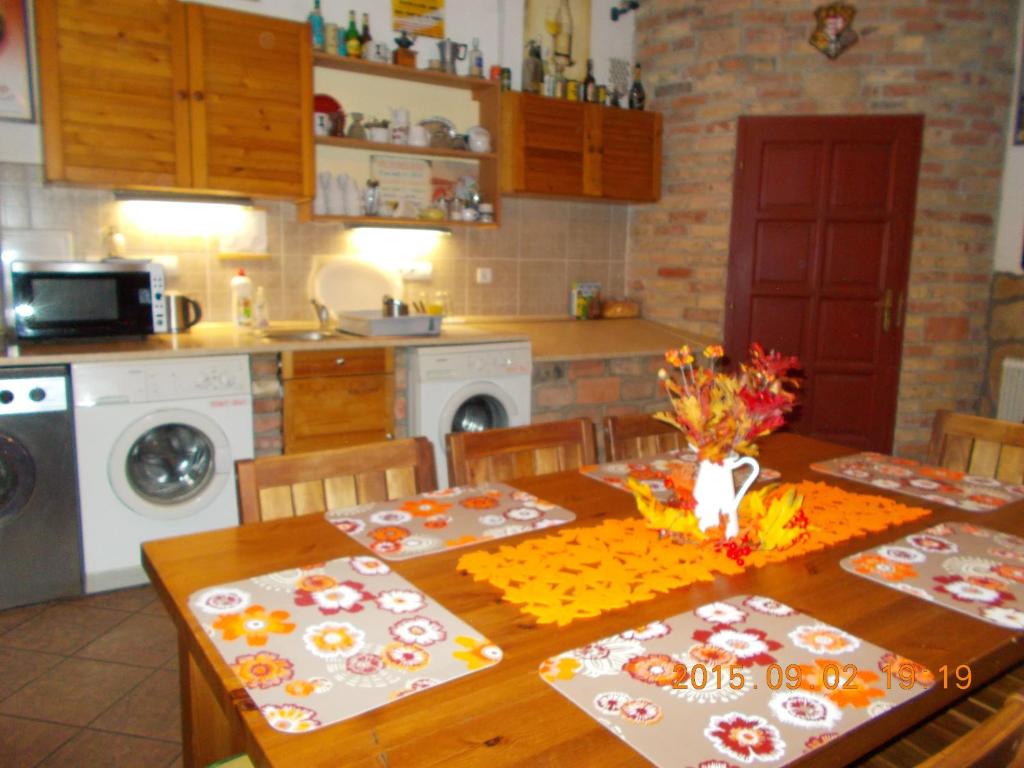 a kitchen with a wooden table with chairs and a dining room at Hungaria Guesthouse in Budapest