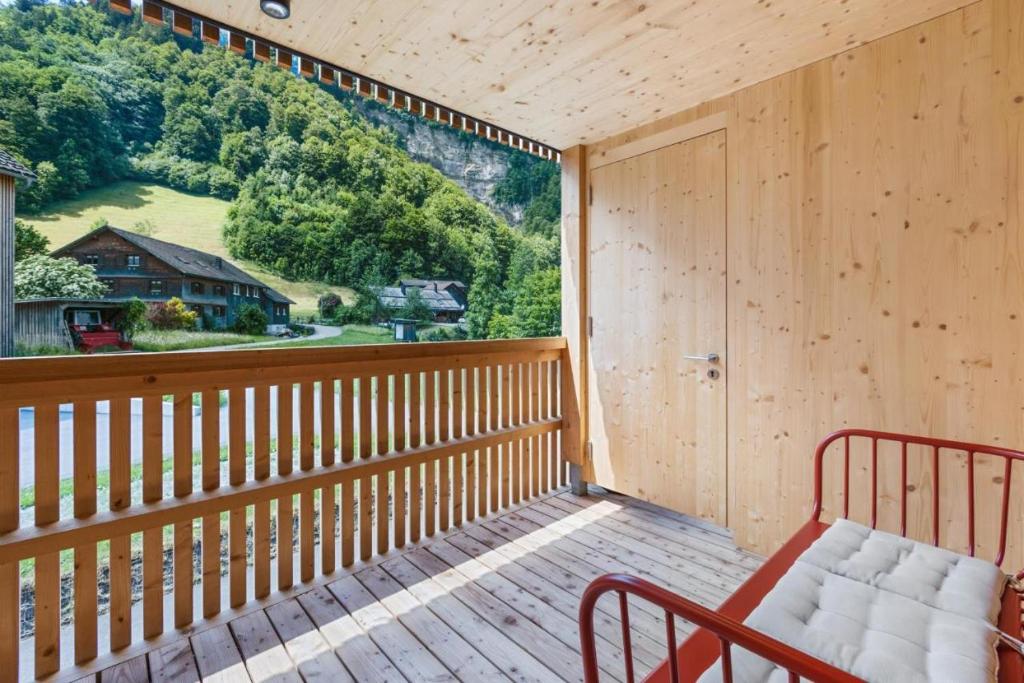 einen Balkon mit einer Bank und einem großen Fenster in der Unterkunft Appartement JOHANN- Urlaub im Herzen des Bregenzerwaldes in Mellau