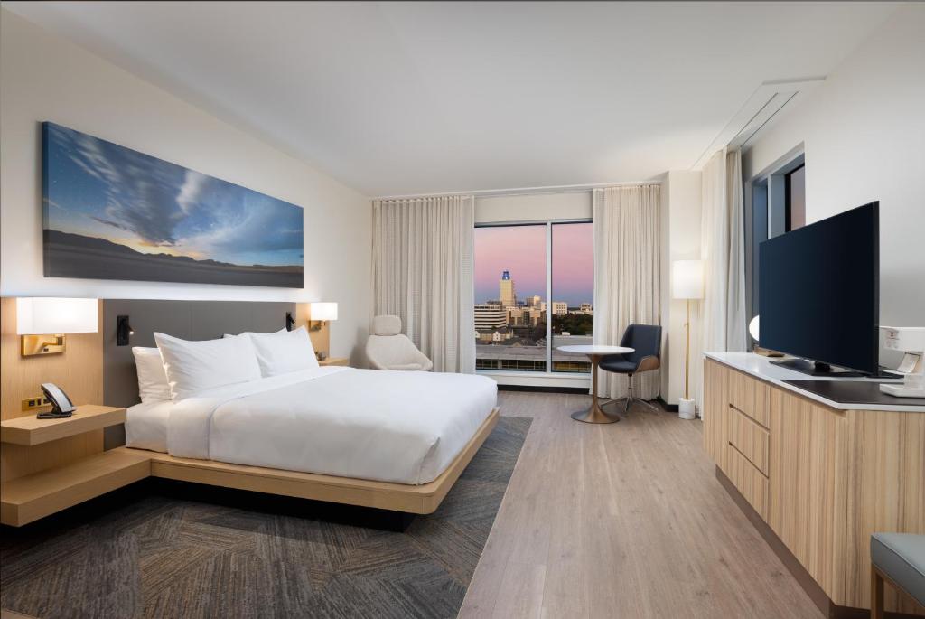 ヒューストンにあるThe Moran CITYCENTREのベッド1台、薄型テレビが備わるホテルルームです。