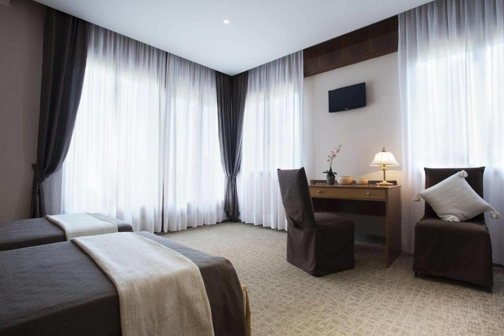 a bedroom with a bed and a desk and a chair at Hotel Grand Torino in Abano Terme