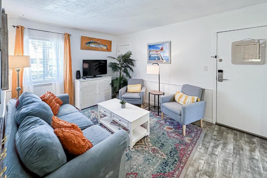 een woonkamer met een blauwe bank en 2 stoelen bij Dunes Villas D4 in Hilton Head Island