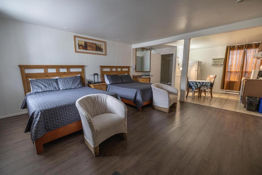 een slaapkamer met een bed en een woonkamer bij Motel Deblois in Sainte-Anne-de-Beaupré