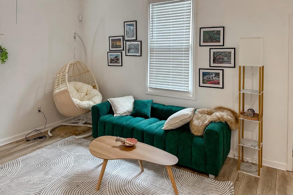 a living room with a green couch and a table at Modern Memories, Unit B in Savannah