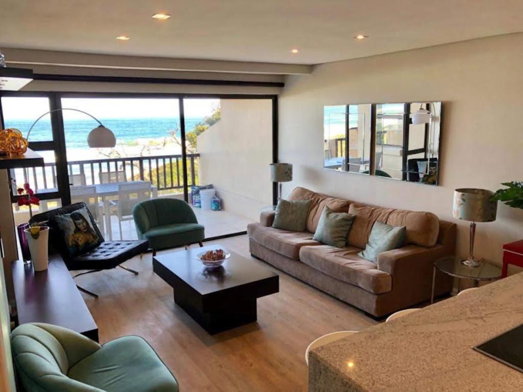 a living room with a couch and a view of the ocean at 6 Dolphin Views La Mercy Beachfront in La Mercy
