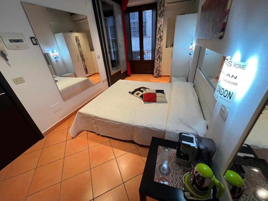 um pequeno quarto com uma cama e um espelho em Cefalù cozy flat em Cefalù