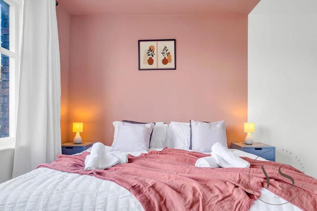 1 dormitorio con 1 cama grande y paredes de color rosa en Gorgeous Longton Studio 1d en Stoke on Trent
