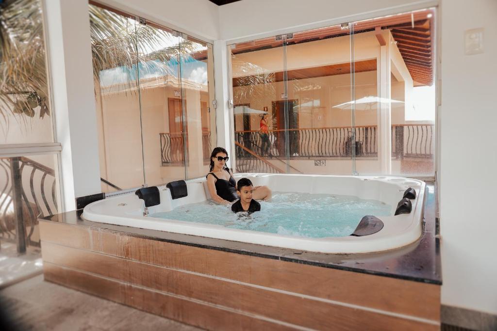 a woman and a child in a bath tub at Pousada Kanto Suites & Spa in Capitólio