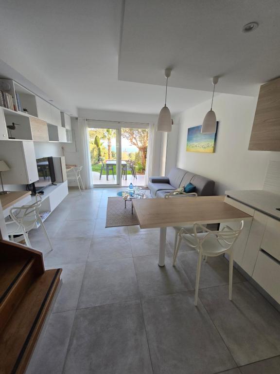 Villa Perle d'or vue mer في سانت رافائيل: مطبخ وغرفة معيشة مع طاولة وكراسي