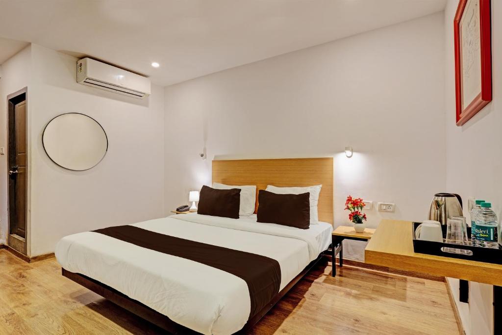 1 dormitorio con 1 cama grande y escritorio en Hotel Qubic Stay Near Delhi Airport, en Nueva Delhi