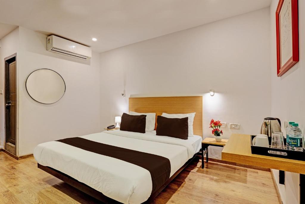 a bedroom with a large bed and a desk at Hotel Qubic Stay Near Delhi Airport in New Delhi