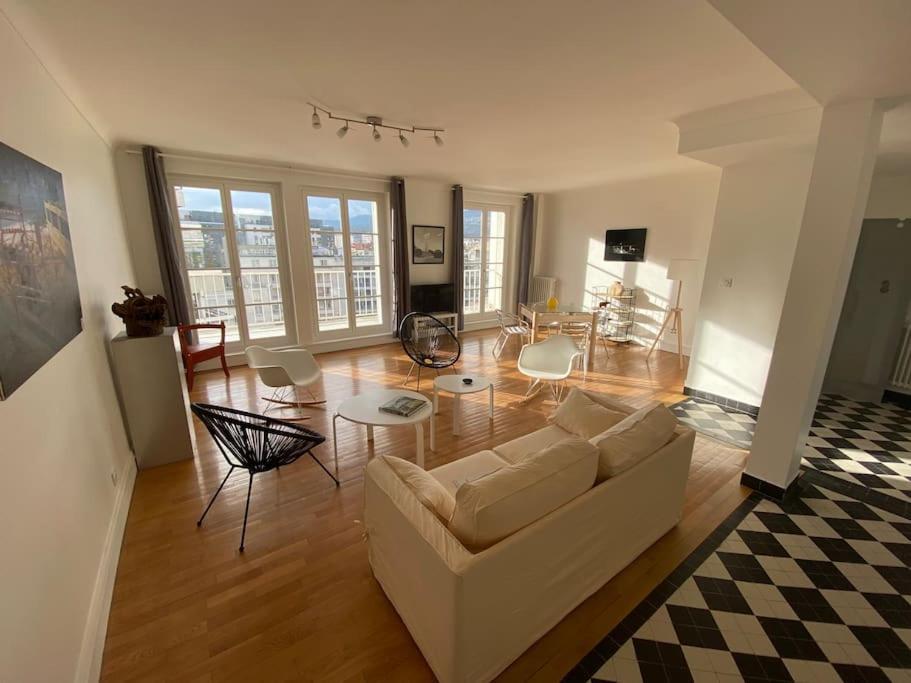 un salon avec un canapé blanc et une table dans l'établissement Spacieux et lumineux Centre Jaude 100m2, à Clermont-Ferrand