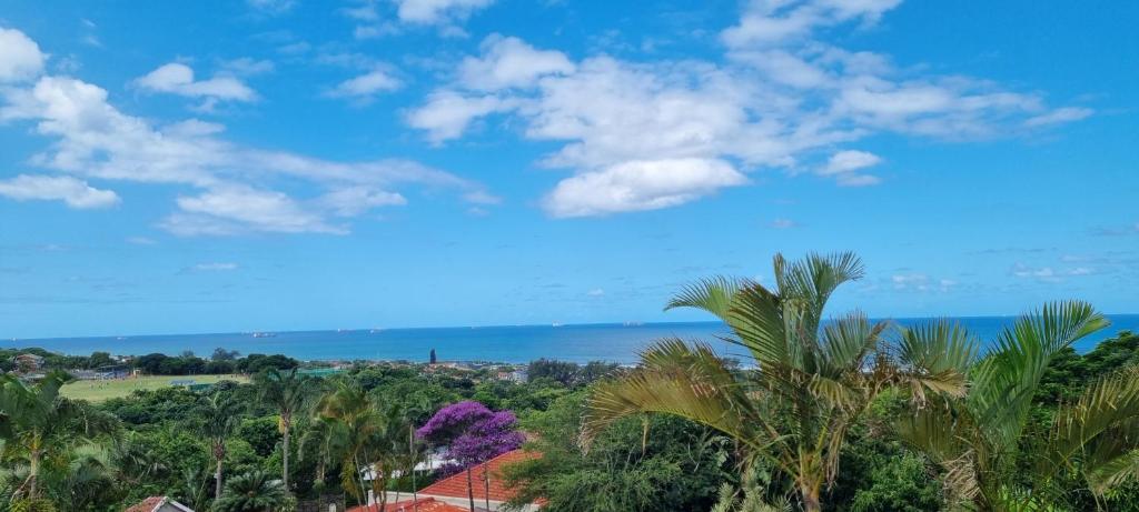 een uitzicht op de oceaan vanuit een resort met palmbomen bij Three Little Birds Guesthouse in Durban