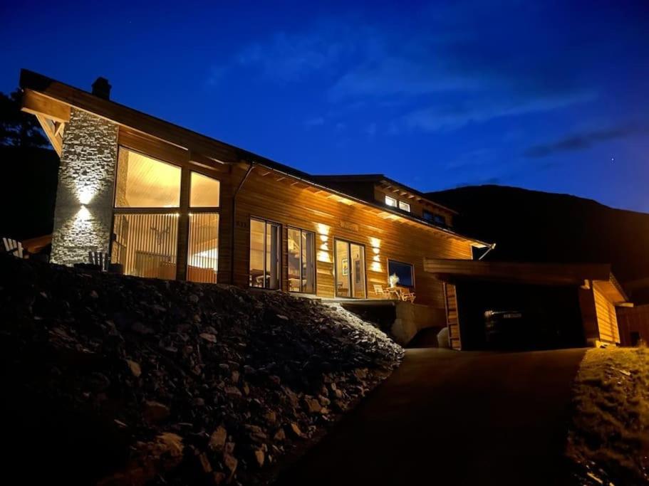 ein Haus in der Nacht mit eingeschaltetem Licht in der Unterkunft Ny, eksklusiv hytte til leie på Voss in Skulestadmo