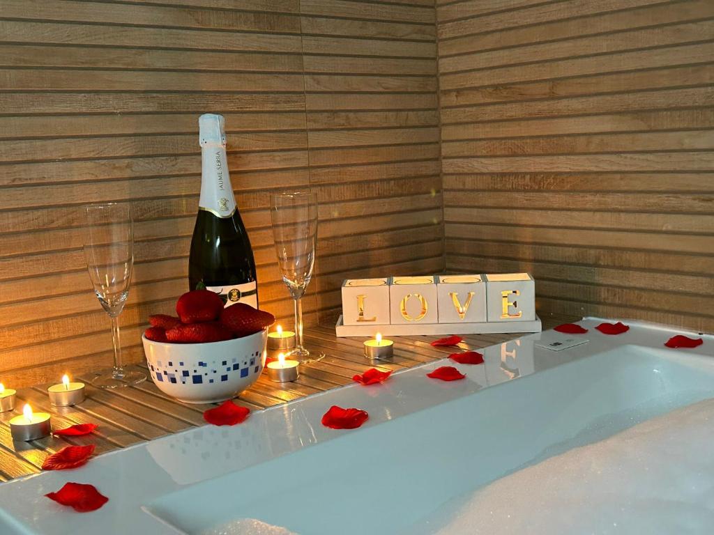 a bath tub with a bottle of wine and candles at La Posada del Pueblo in Arbancón