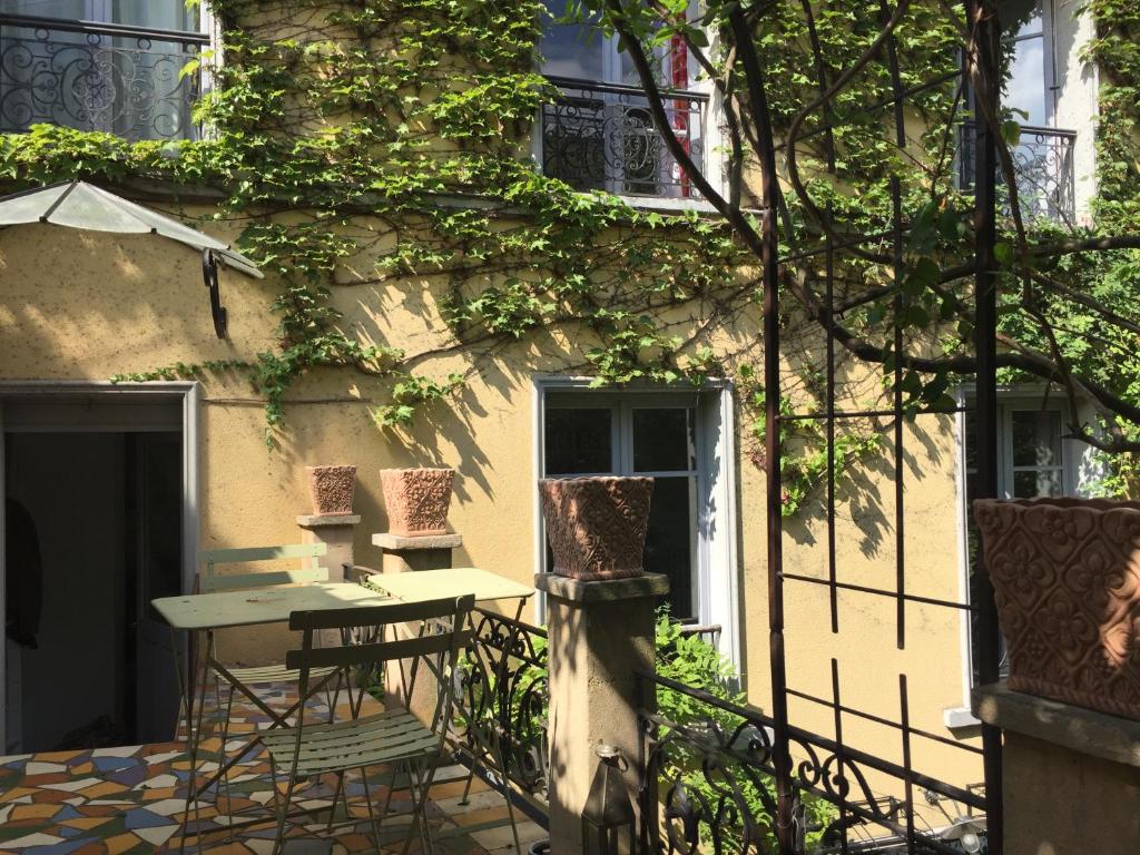 une table et des chaises devant un bâtiment dans l'établissement Magnifique maison 15 minutes du centre historique de Paris, aux Lilas