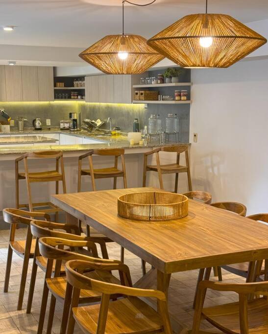 a kitchen with wooden tables and chairs and lights at CASA ALMA LUXURY HOME in Mendoza