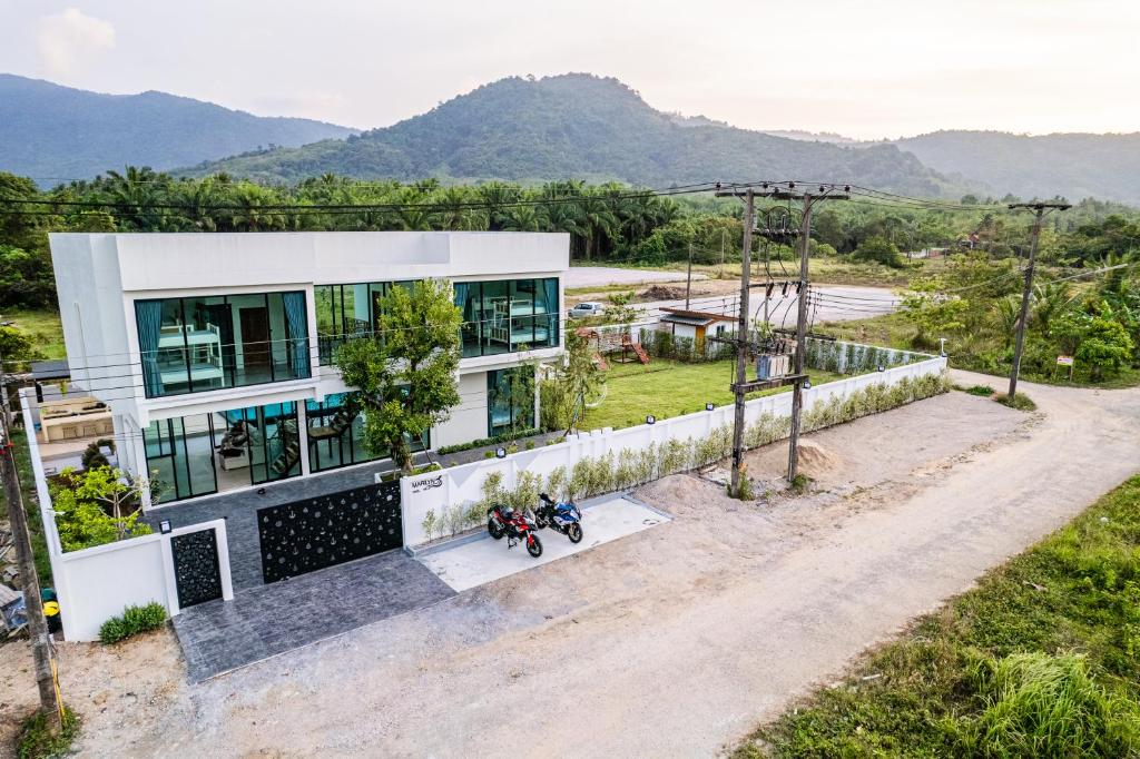 una vista aérea de una casa con montañas en el fondo en มาริลิน พูลวิลล่า ขนอม, 
