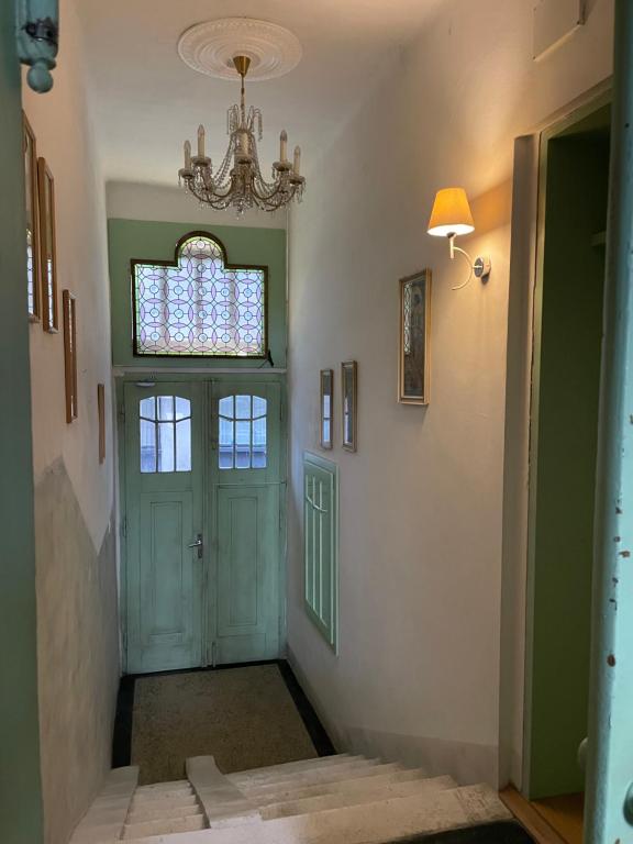 a hallway with a green door and a chandelier at MINATO Apartments Ostrava center in Ostrava