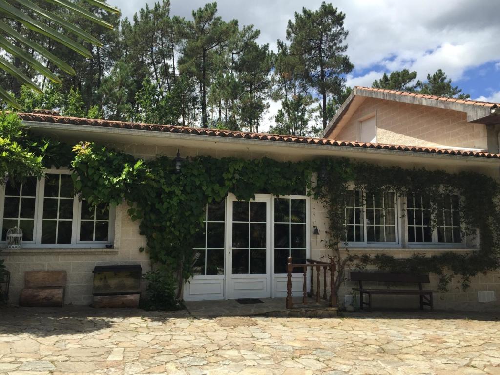 a house with a bunch of ivy growing on it at Agro da Gandarela in Teo