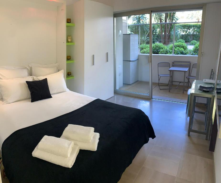 une chambre avec un grand lit avec deux serviettes dessus dans l'établissement Studio Cannes Croisette, à Cannes