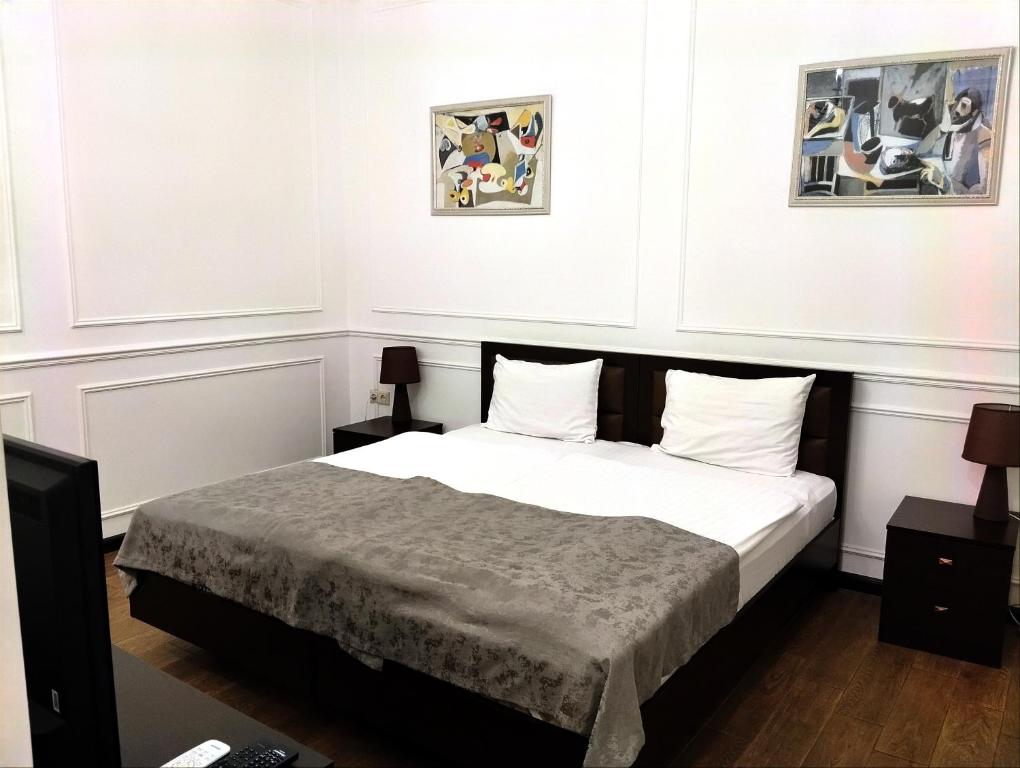 a bedroom with a bed and two pictures on the wall at BLH in Yerevan