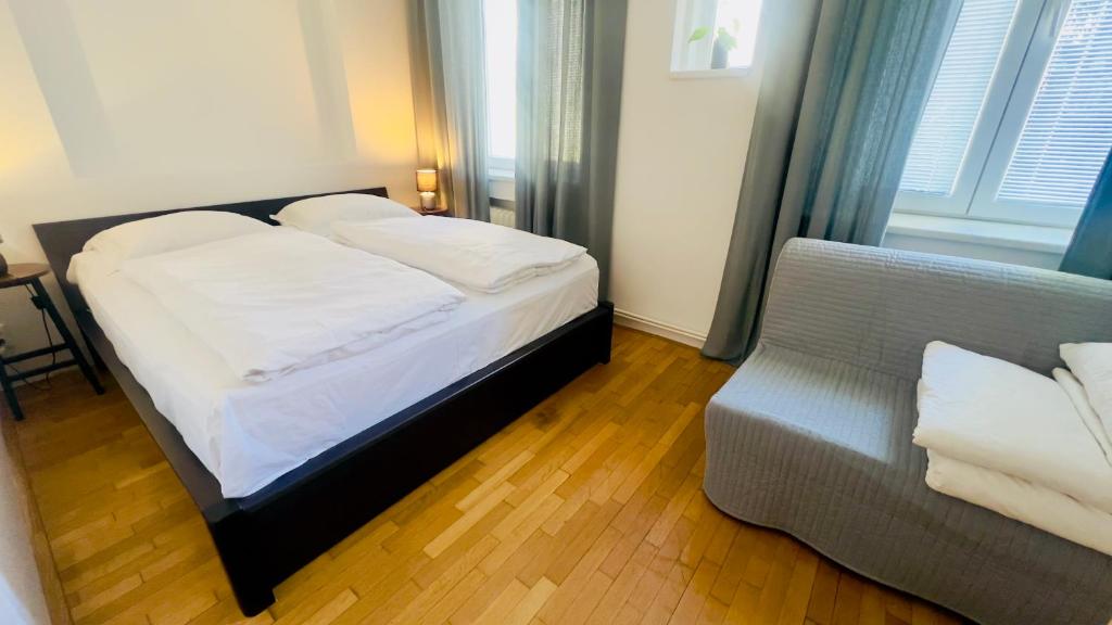 ein kleines Schlafzimmer mit einem Bett und einem Stuhl in der Unterkunft Apartmán l Praha centrum in Prag