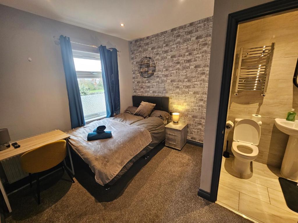 a bedroom with a bed and a bathroom with a toilet at Tudor Road House in Leicester