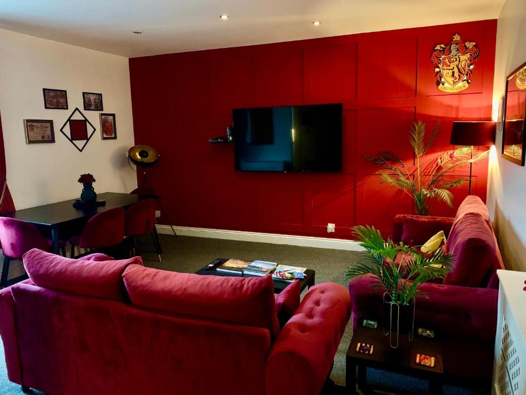 阿尼克的住宿－The Wizard's Loft，客厅设有红色的墙壁和红色的家具
