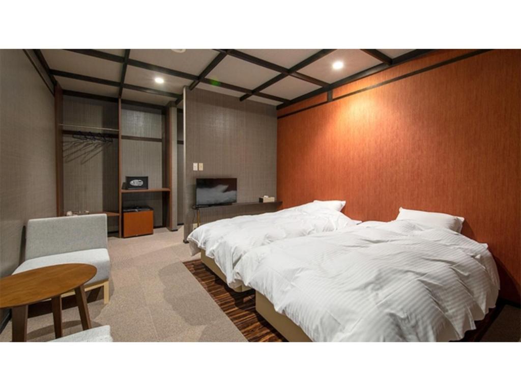 a bedroom with a large white bed and a table at Taiheian - Vacation STAY 57436v in Sakai