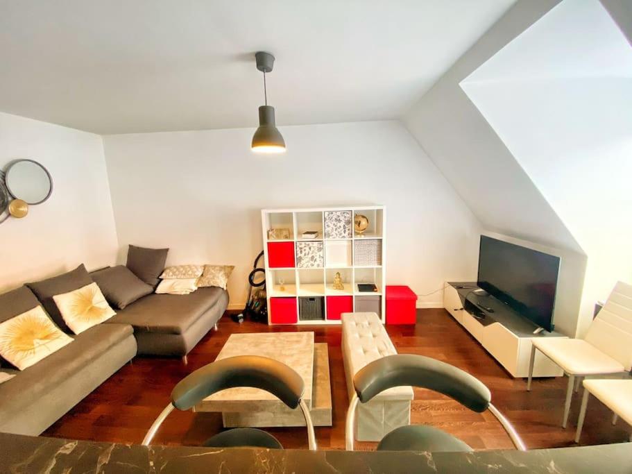 a living room with a couch and a tv at Le Nouveau Moulin by concierge city in Lille